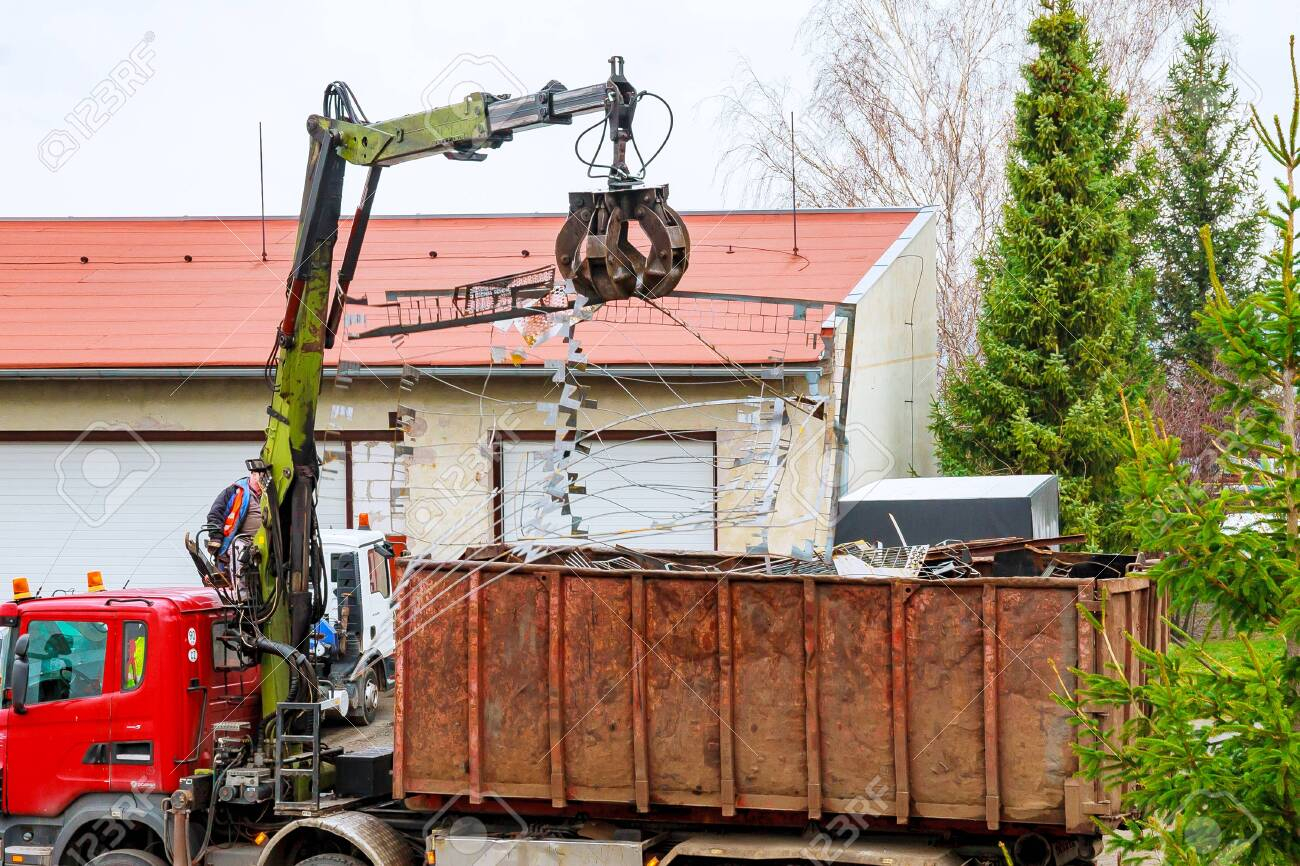 146967762-a-grapple-truck-loads-scrap-industrial-metal-for-recycling-.jpg