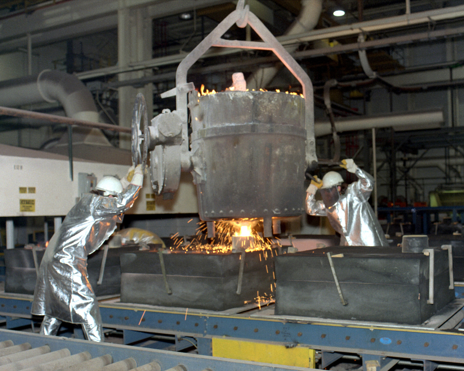 everette-olive-and-jeff-boese-pour-molten-metal-from-a-foundry-bucket-at-the-79beaa-1600.jpg
