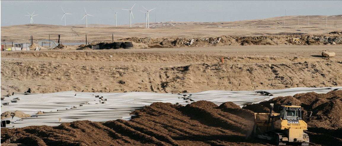 Old windmill blades being bured.PNG