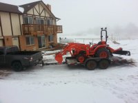 Tractor on trailer behind truck.jpg